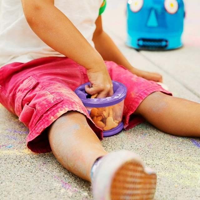 baby hand reaching into purple snack cup