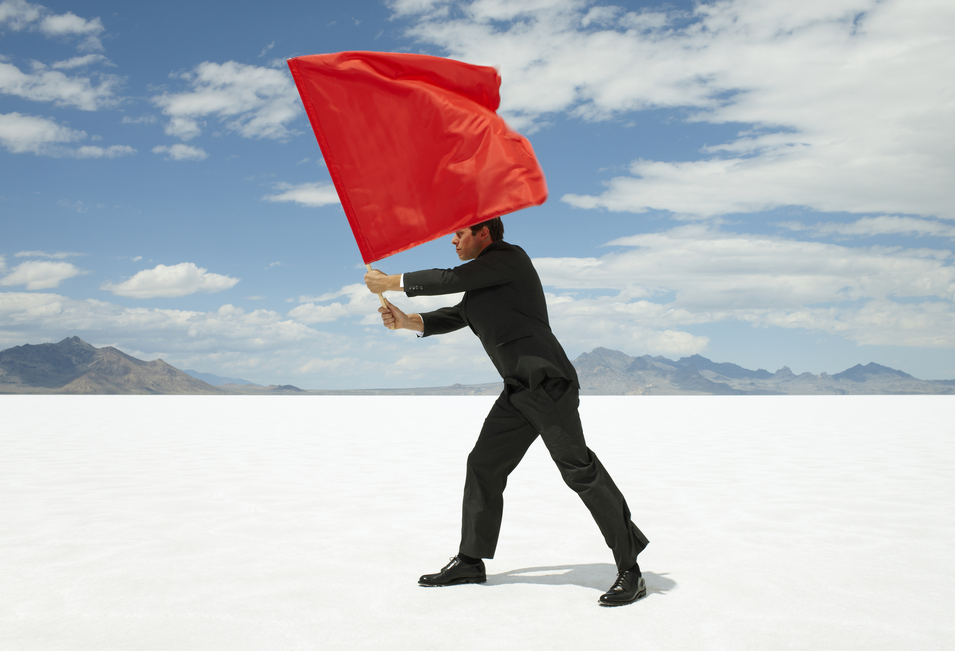 man in a suit waving a red flag