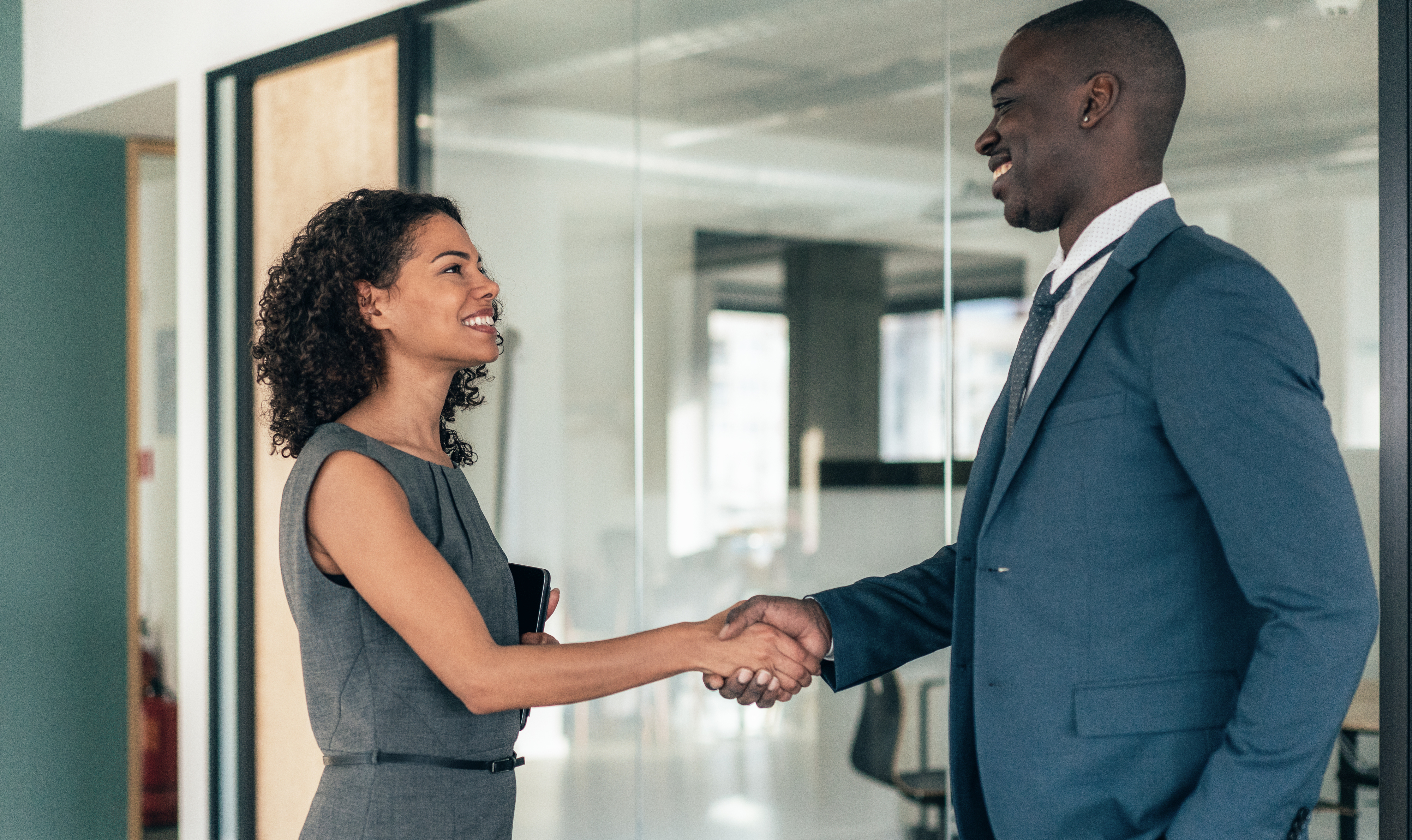 man and woman shaking hands at a job interview