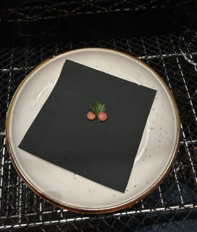 Two ibuprofen pills on a napkin, which is on top of a plate
