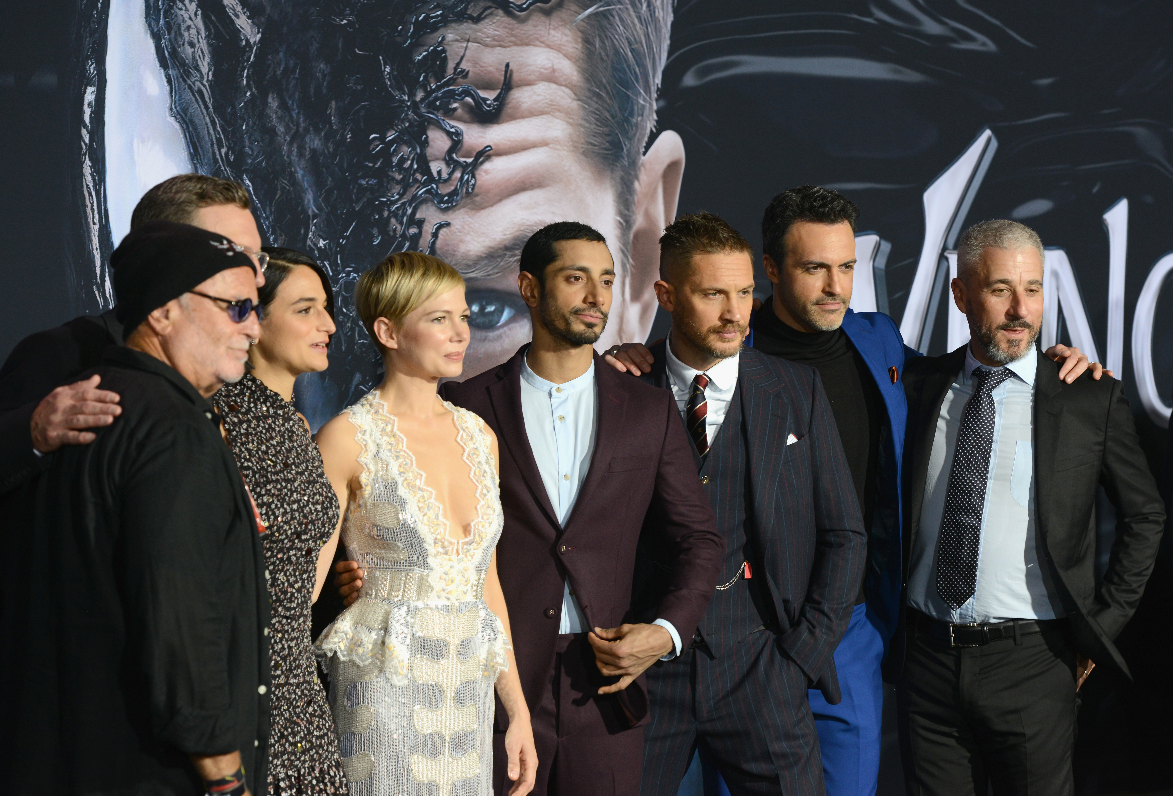 Venom cast members, including Tom Hardy, Riz Ahmed, and Michelle Williams, standing together at a media event
