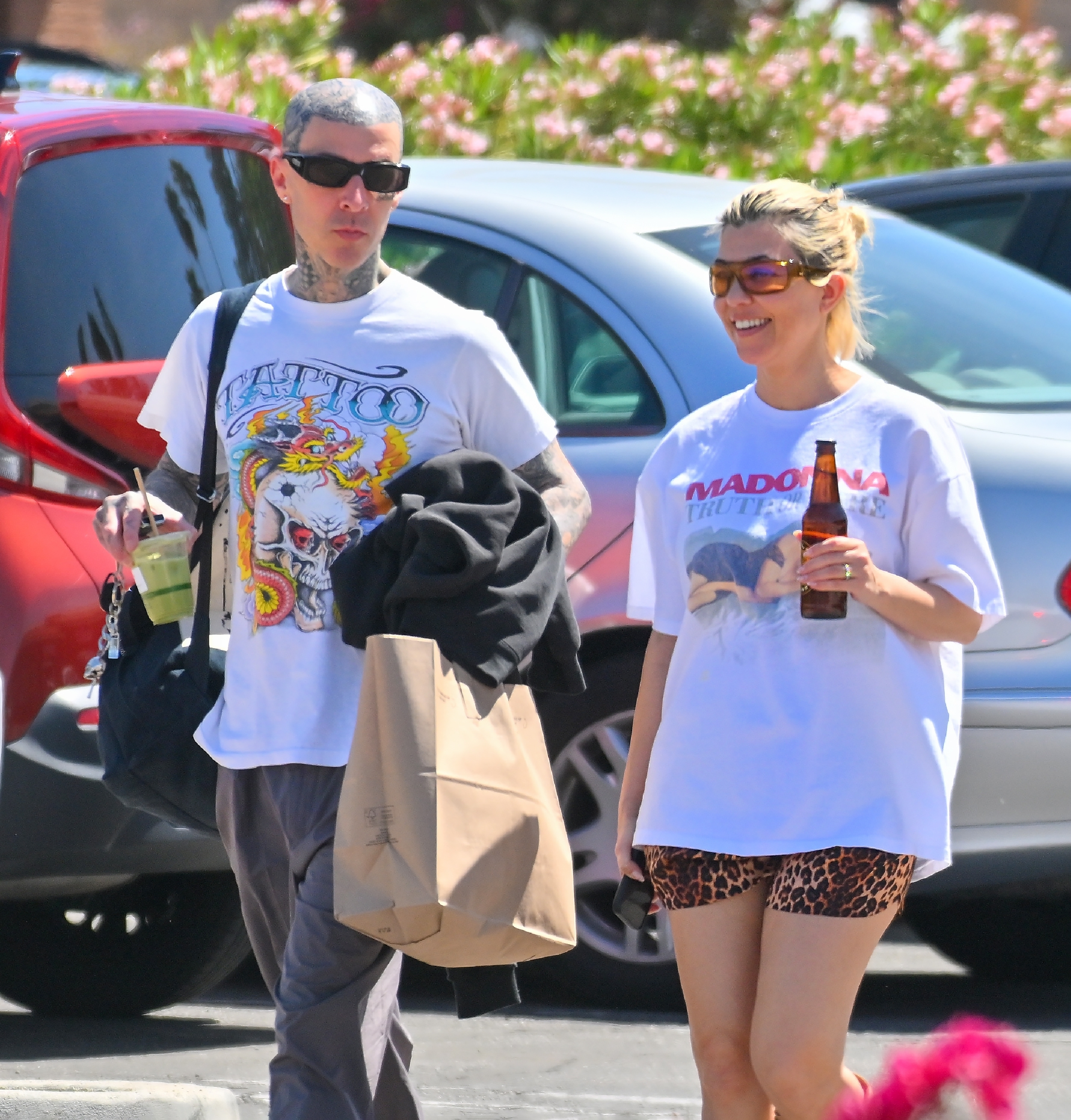 Close-up of Travis and Kourtney wearing T-shirts and walking together outside