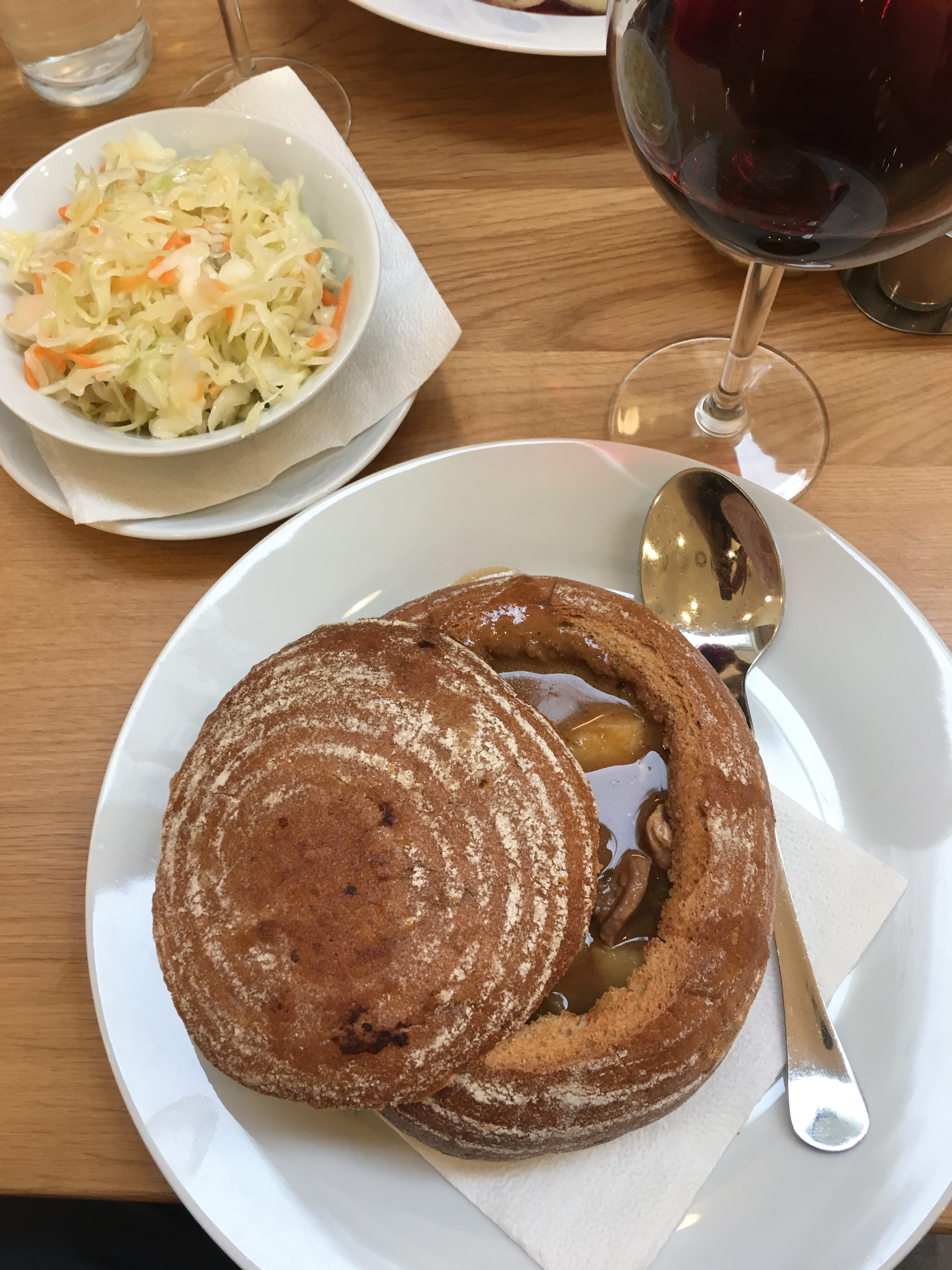 bread bowl with soup next to a side of coleslaw