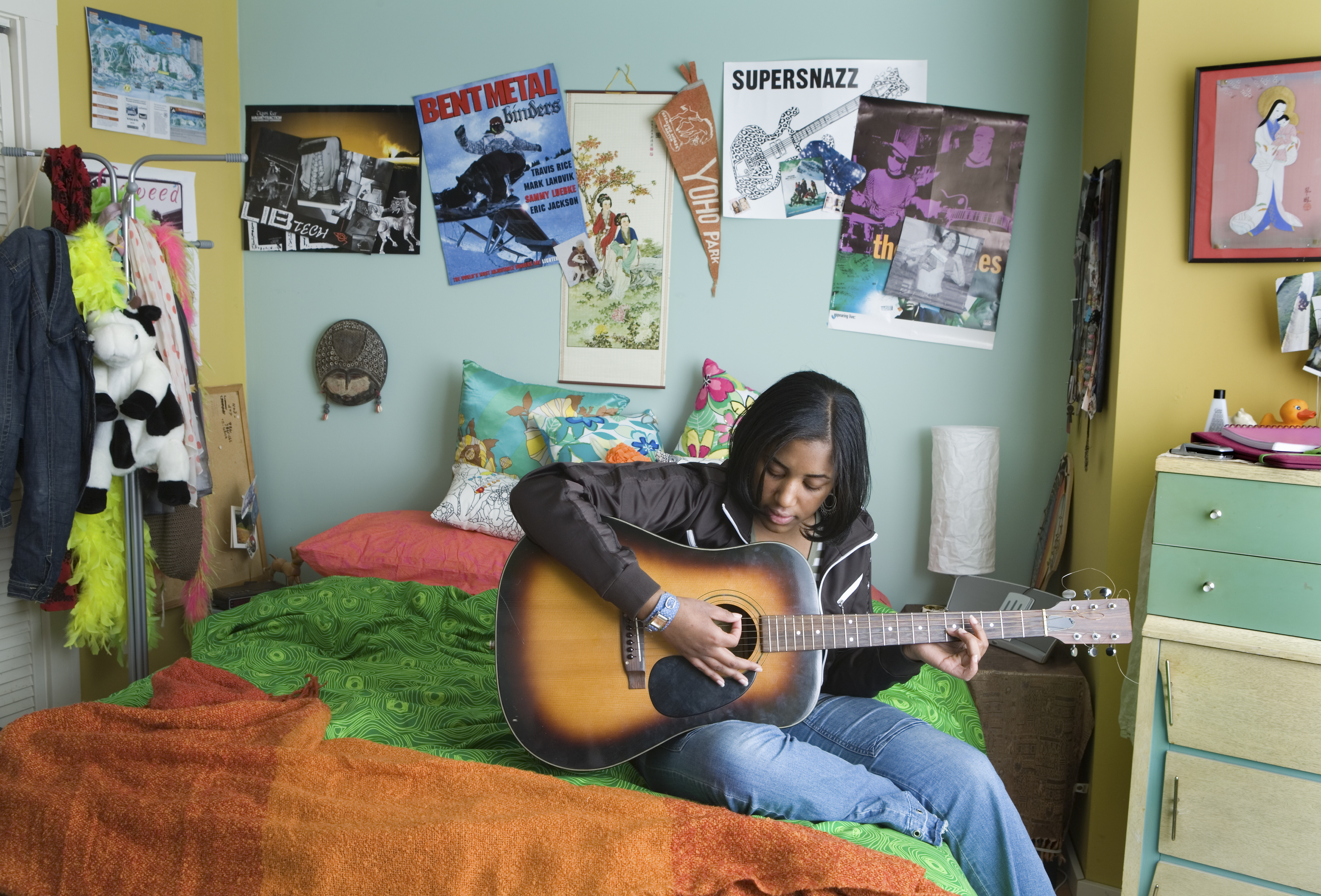 a person playing a guitar inside their bedroom