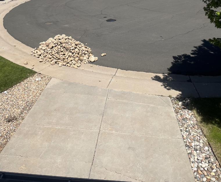 a pile of rocks in front of someone's driveway