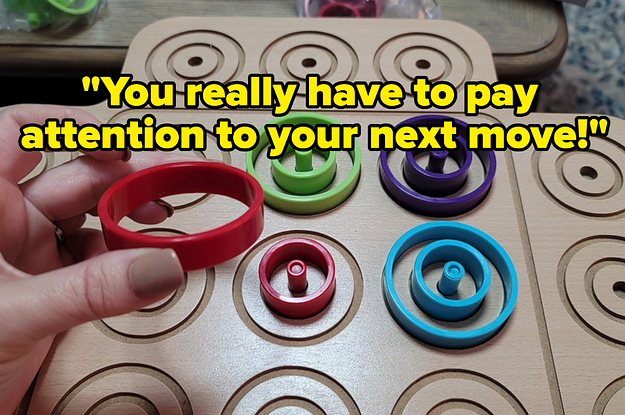 a reviewer's hand holding up a red circular piece above the game board and text that reads you really have to pay attention to your next move