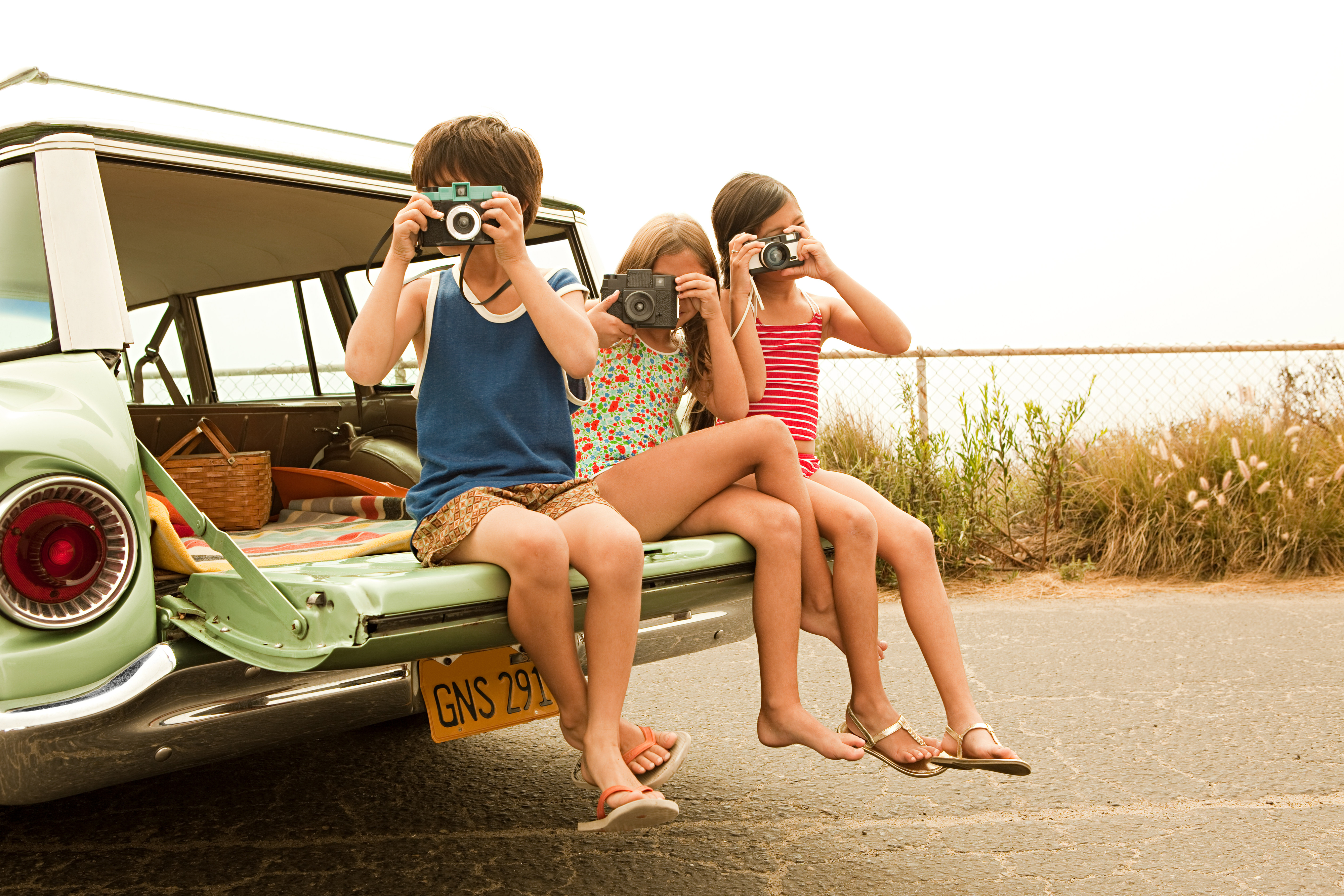 3 siblings in the car taking pictures with camera