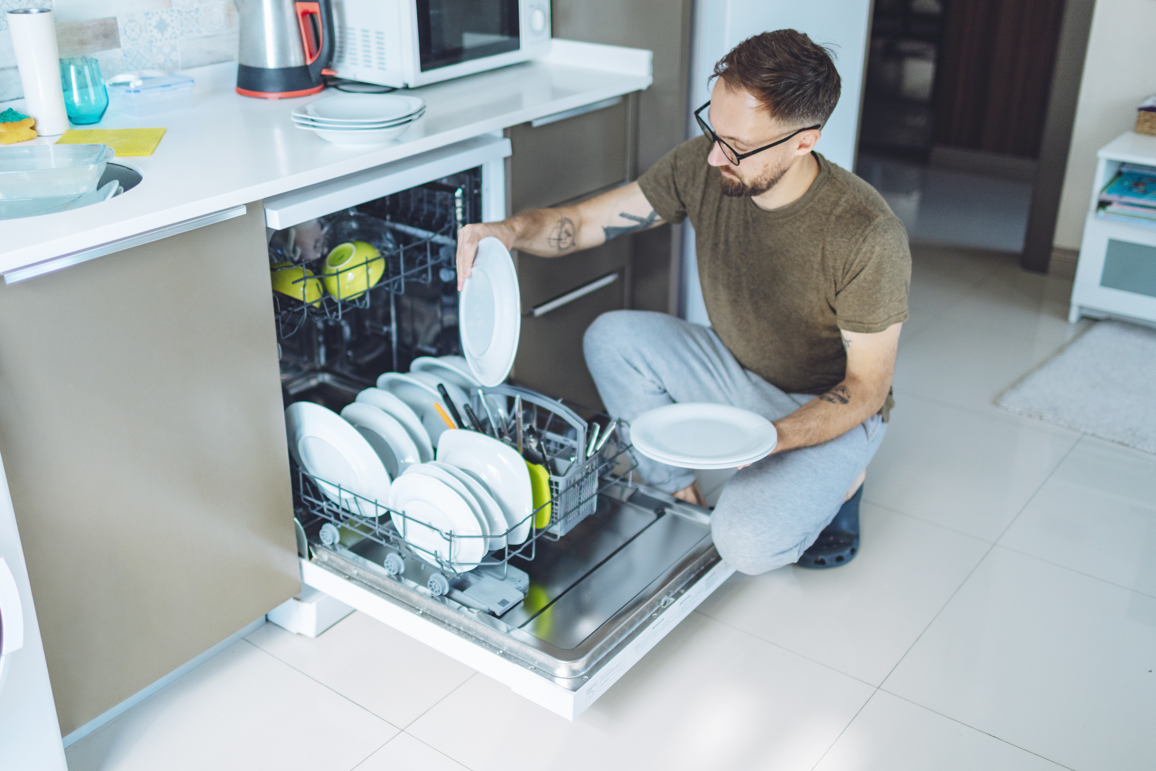 Man unloading a dishwasher