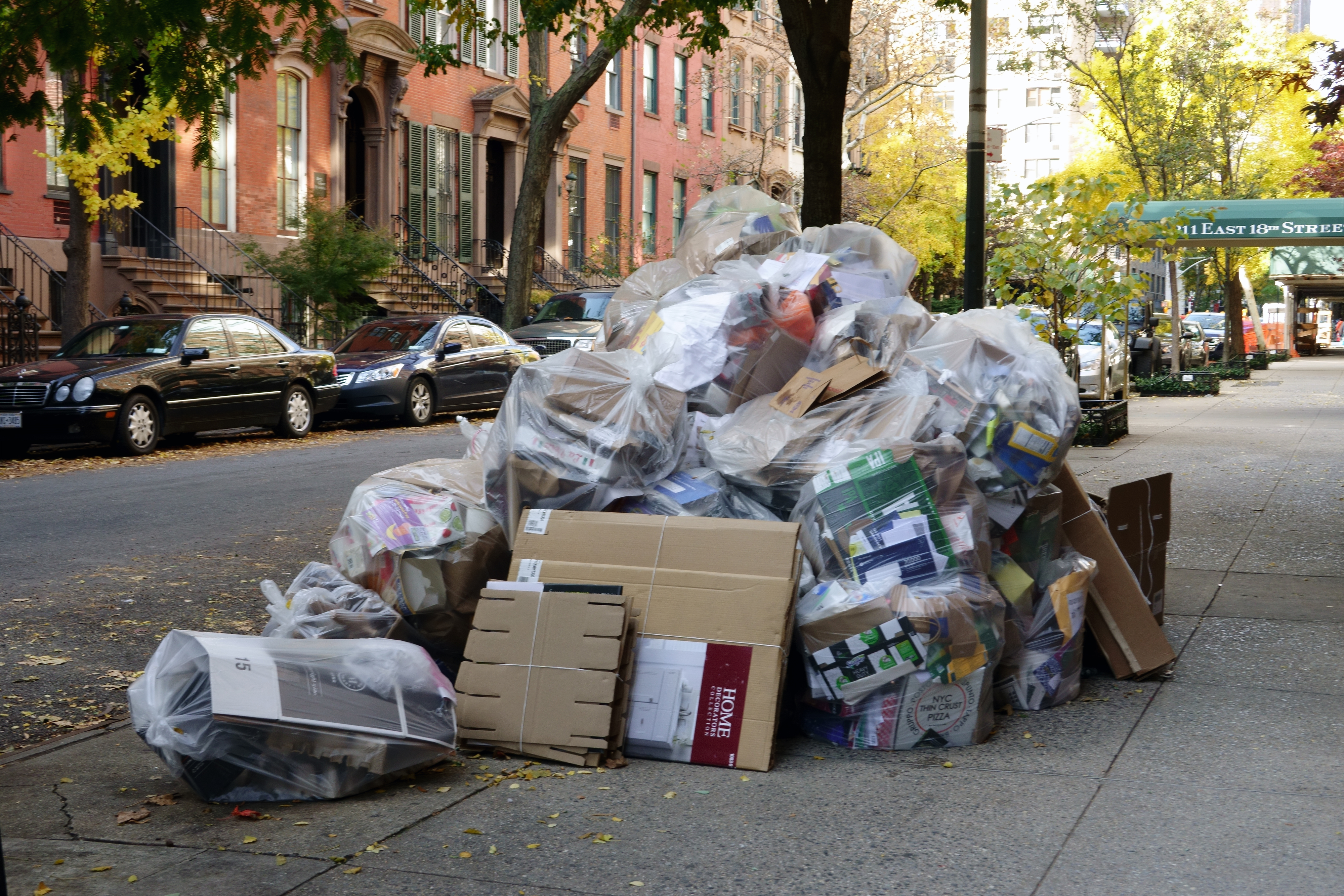 Trash piled on the side of a city sidewalk
