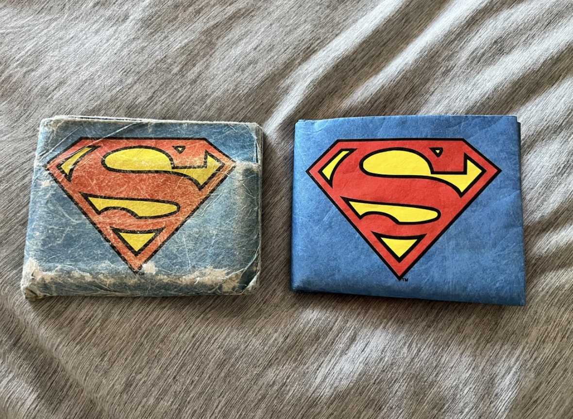 The old &quot;Superman&quot; wallet is a faded blue and badly frayed