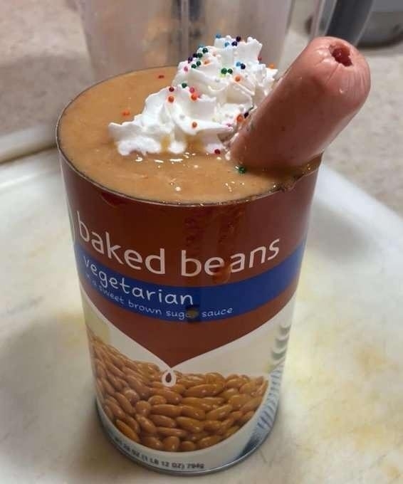 can of baked beans opened with a hot dog for a straw and cool whip and sprinkles on the top
