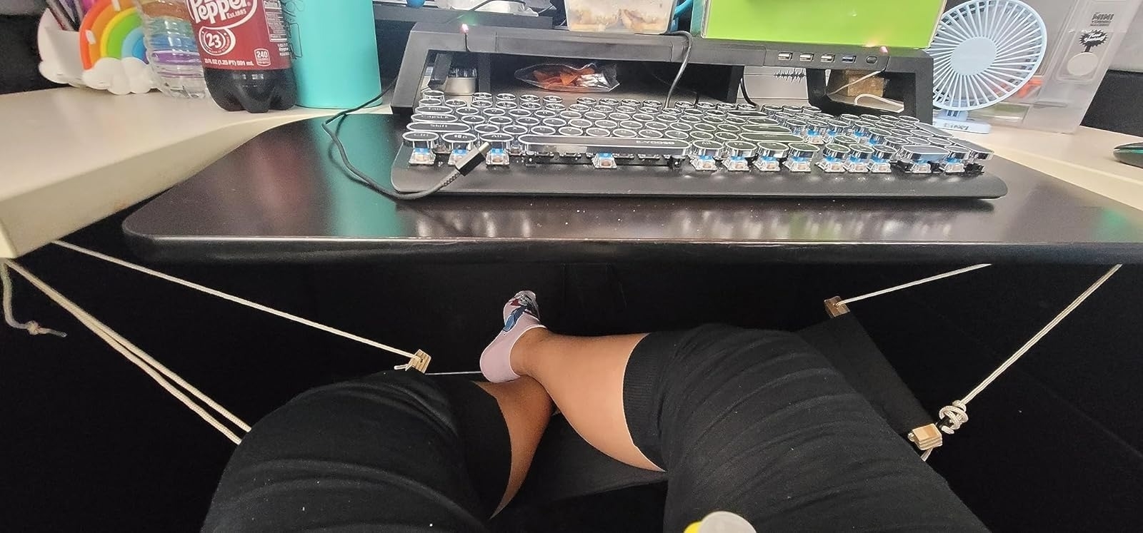 reviewer resting feet on desk-sized foot hammock