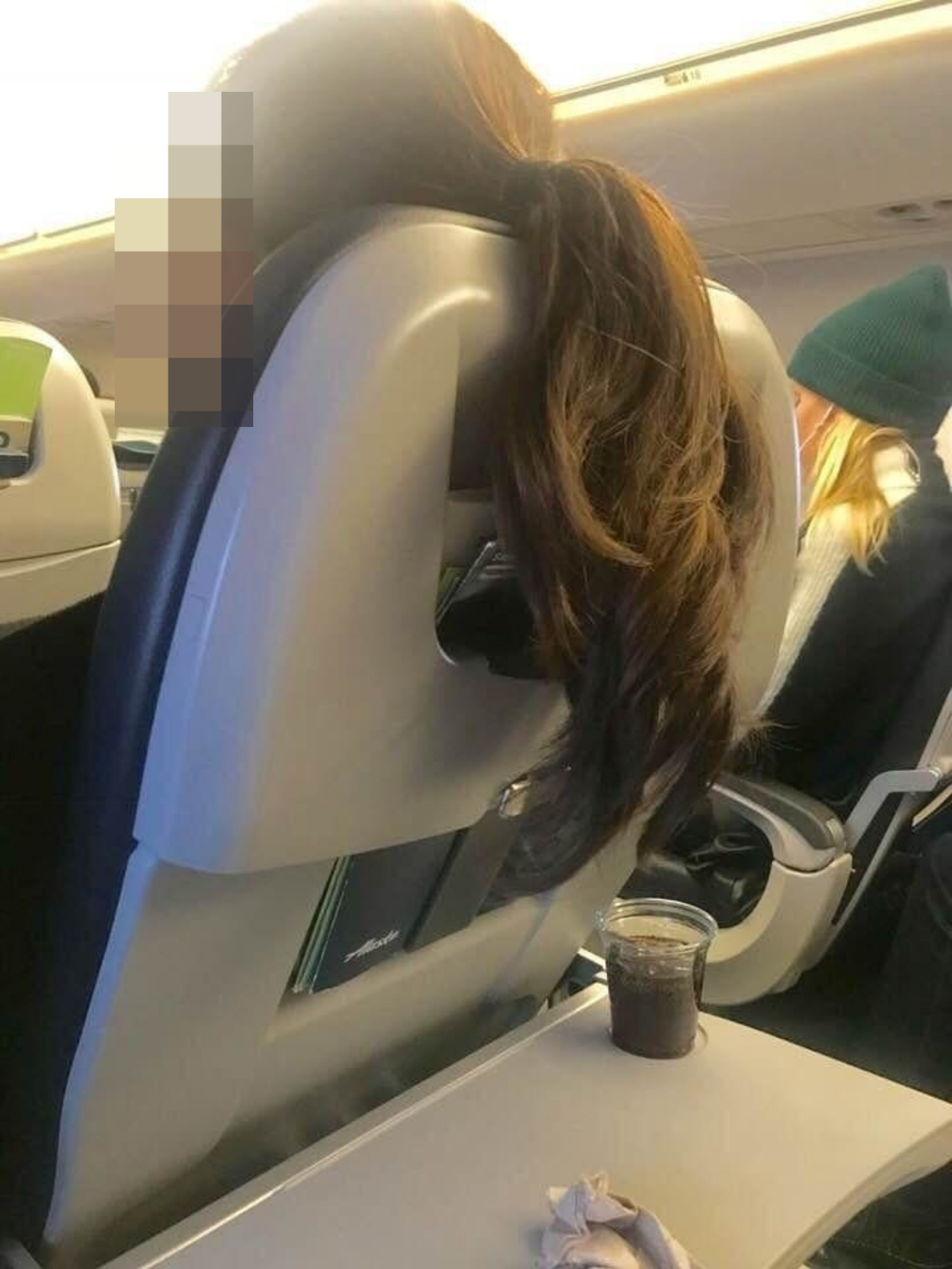 Someone&#x27;s hair hanging over their seat