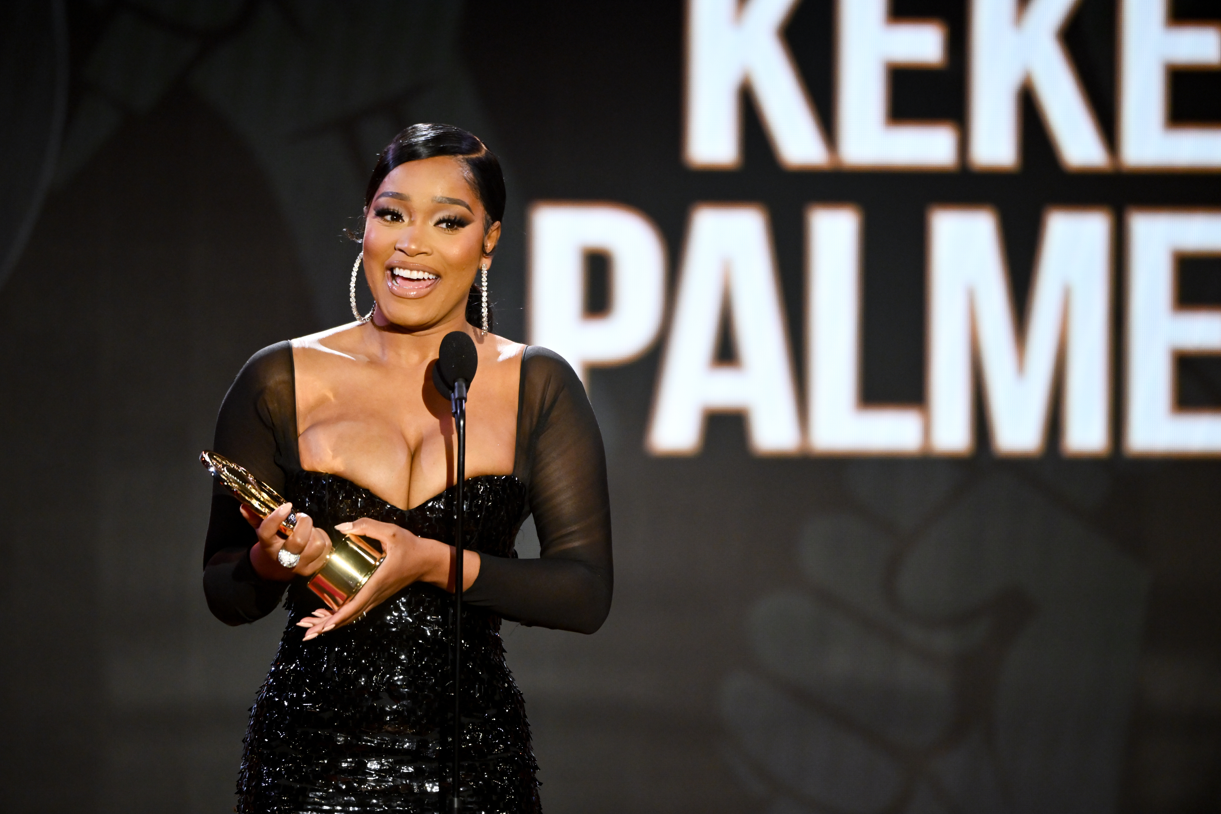keke accepting an award on stage