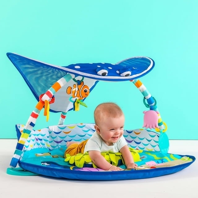 A baby plays on an activity gym