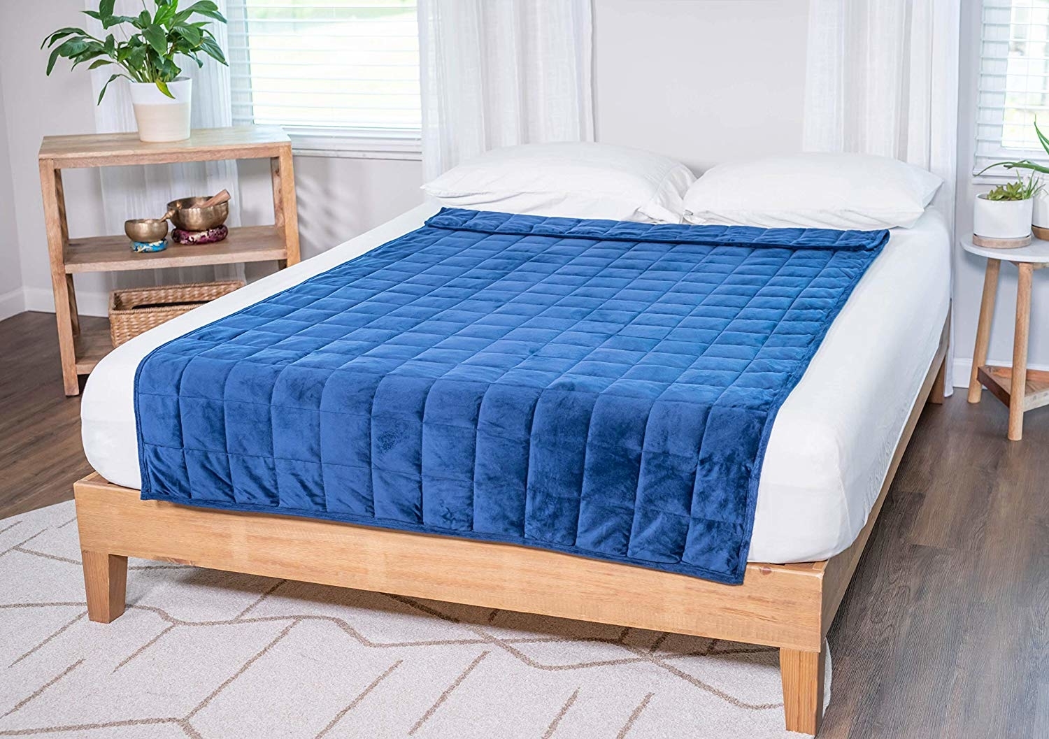 A blue weighted blanket on the bed