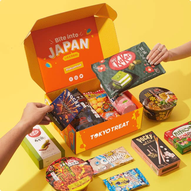 hands pulling snacks out of an orange Tokyo Treat box