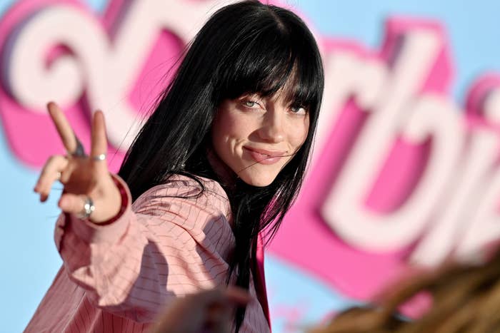 Close-up of Billie smiling and giving a peace sign at the Barbie premiere