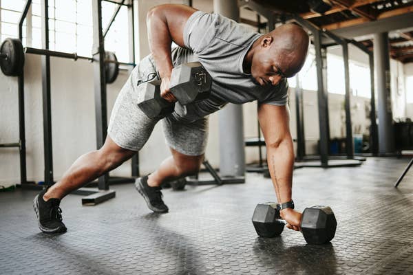 A man using weights during pushups in a gym