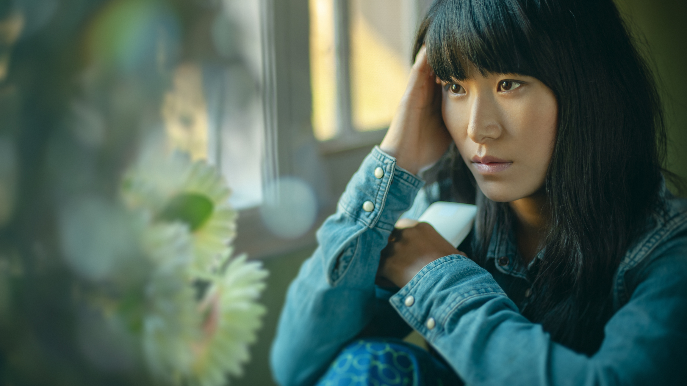 A woman looking sad looking out a window
