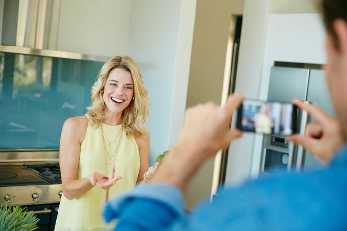 a man taking a photo of a woman on his phone