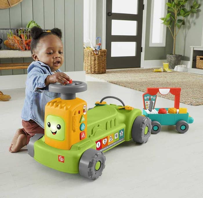 a small child playing with the ride-on tractor toy