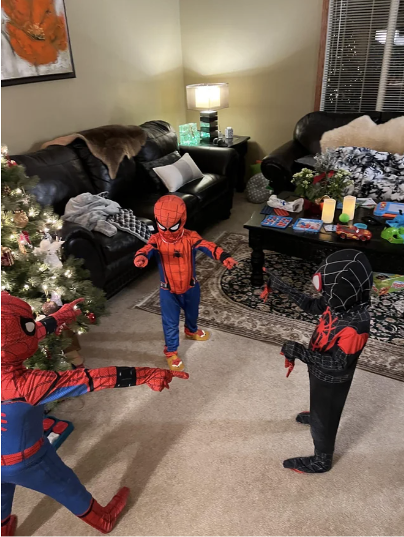 Kids dressed as Spider-Man pointing to each other
