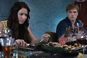 Katniss and Peeta sitting down to a feast in The Hunger Games