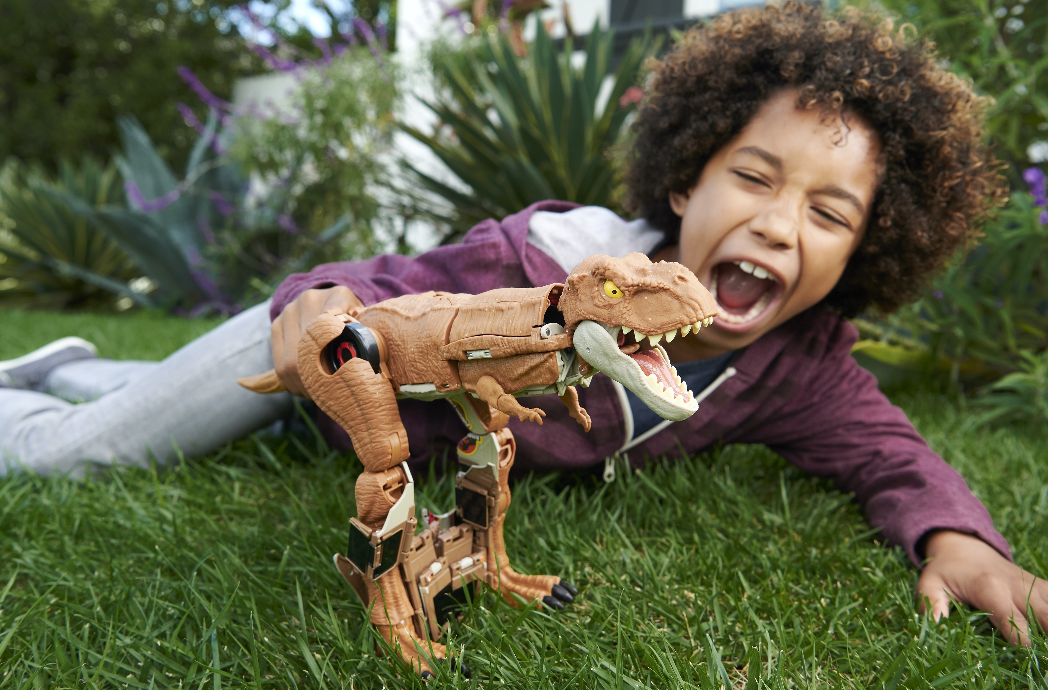 a child pretends to be a t rex while playing with the transforming dinosaur