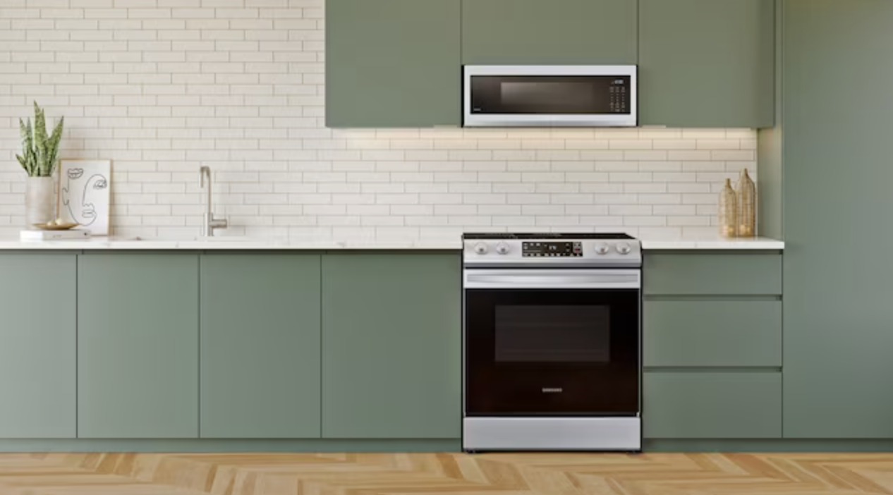 the black and silver oven range in kitchen with green cabinets