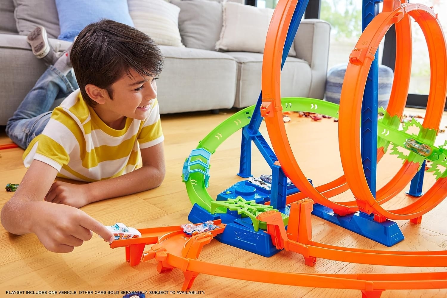 a young child playing with the hot wheels track