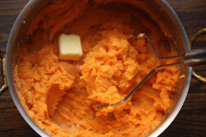 Sweet potato mash in a mixing bowl with butter