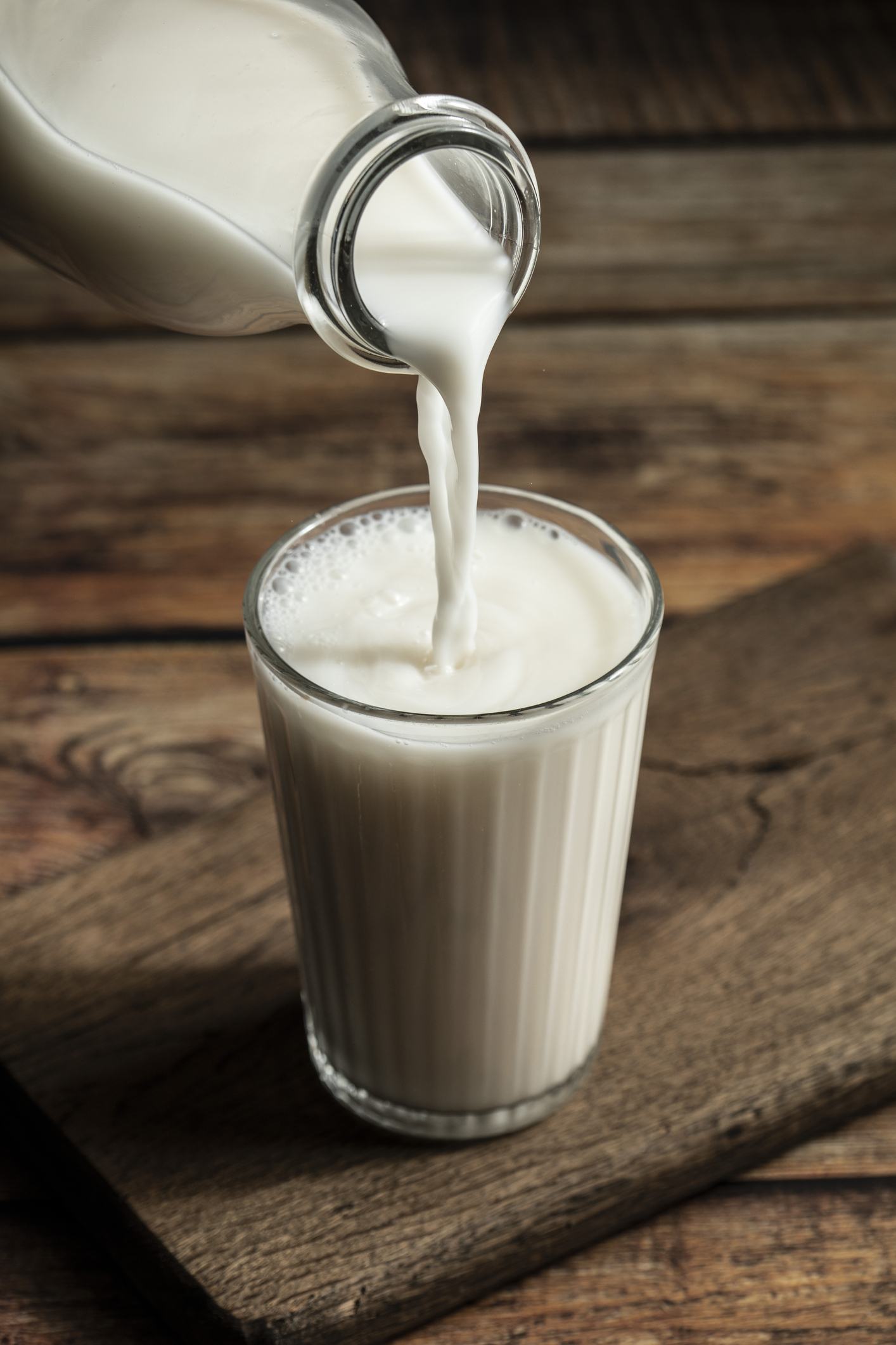 Someone pouring milk into a glass