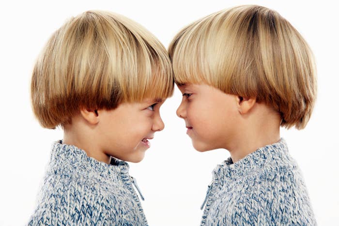 Two twin boys looking at each other and touching foreheads
