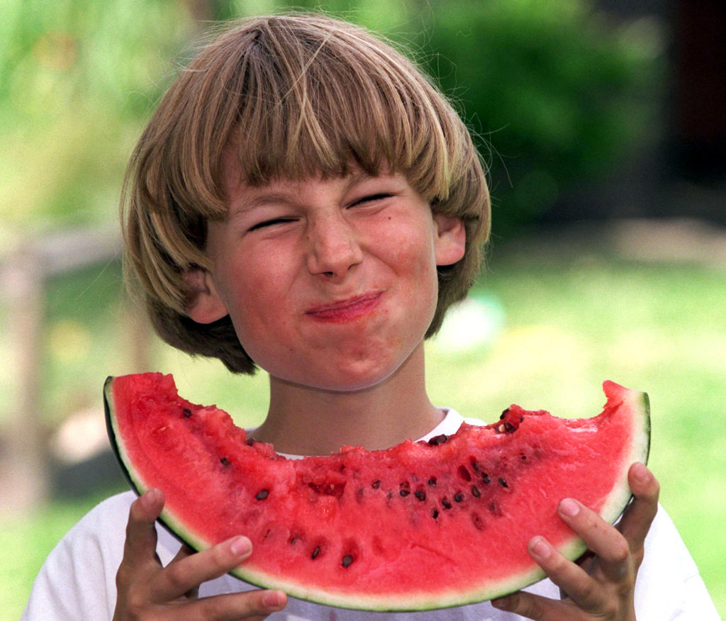 vintage photo of a kid eating a watermelon slice