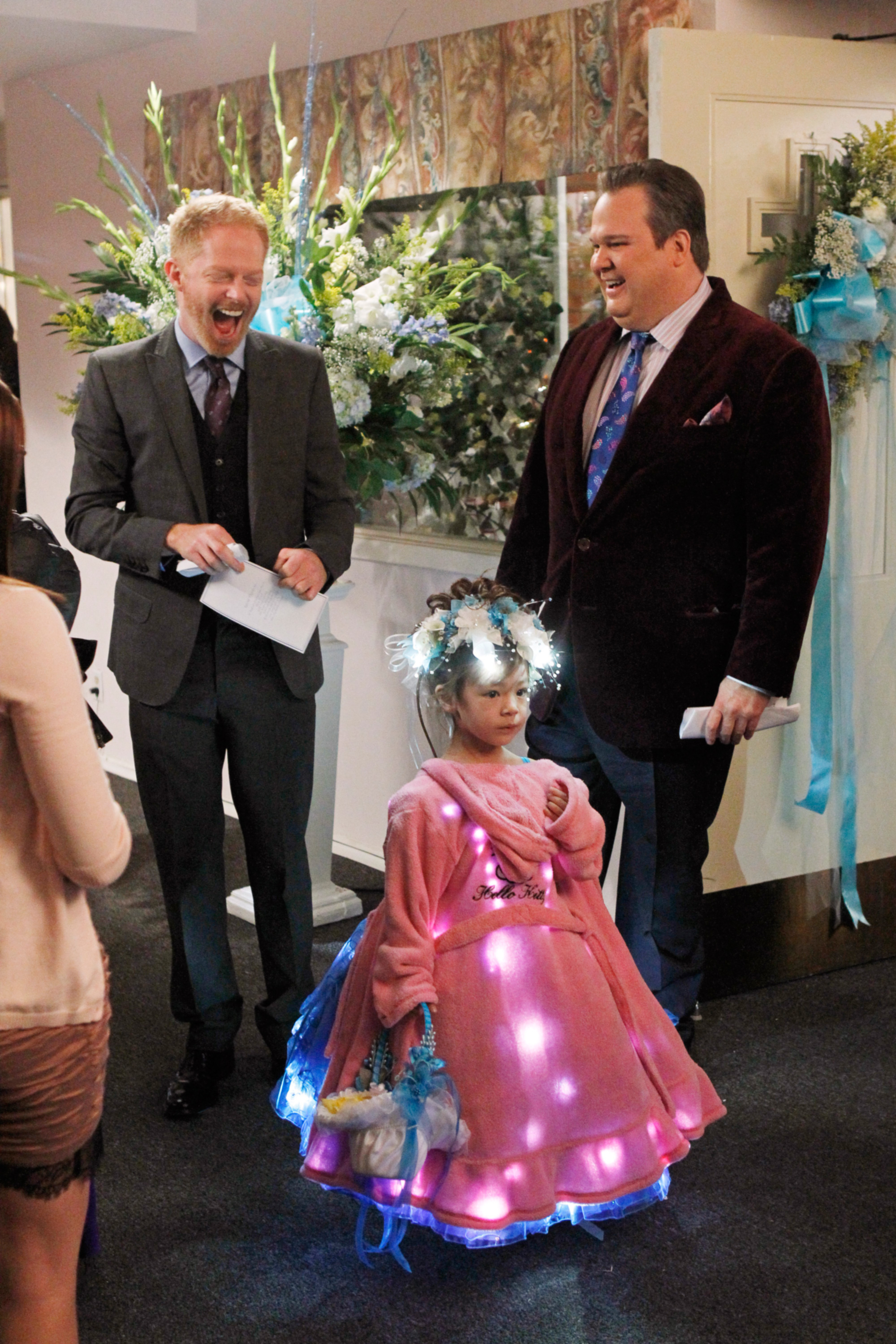 lily as a flower girl with her dads looking excited