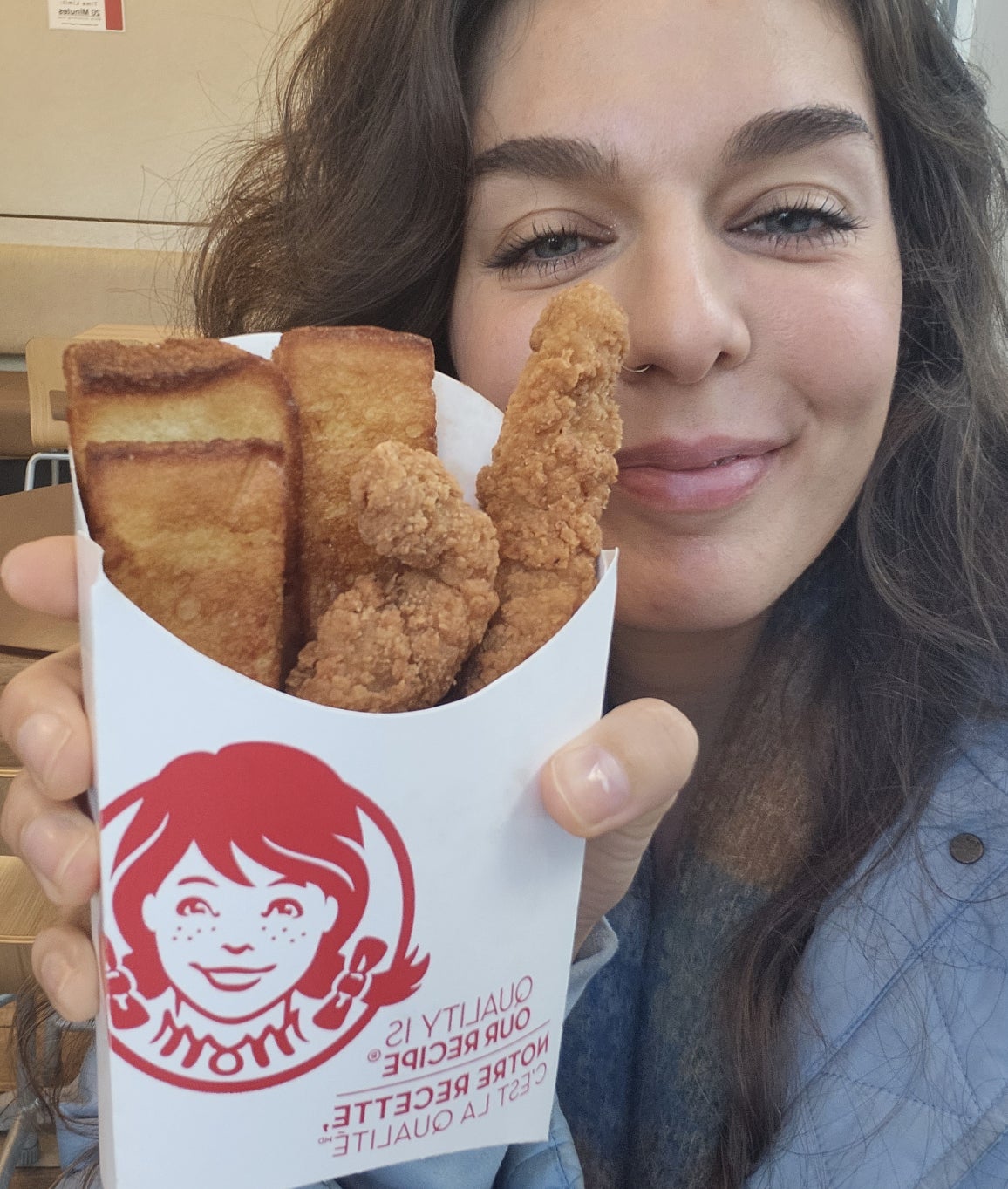 brittany holding up the french toast and chicken strip combo