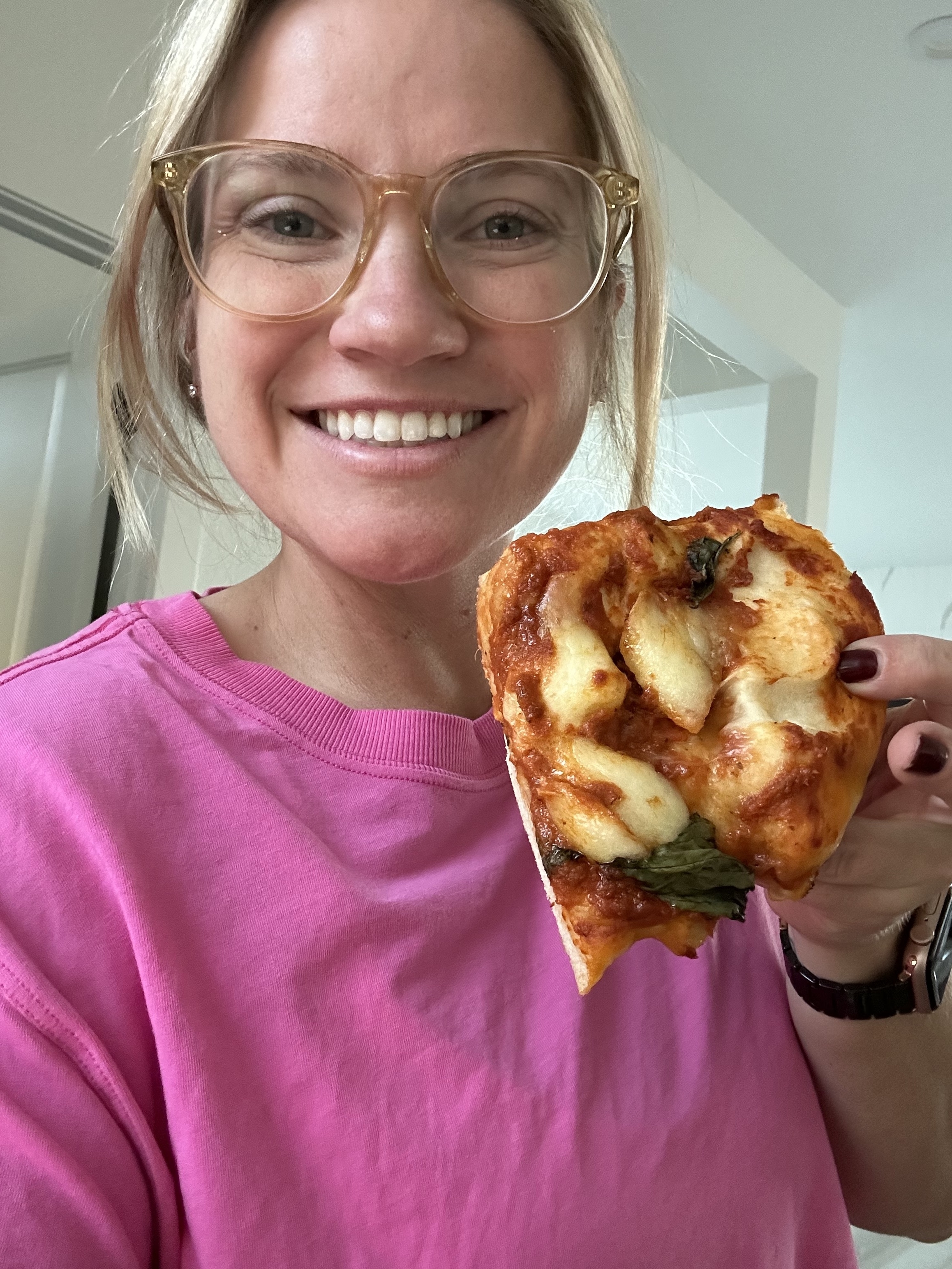the author holding a piece of pizza
