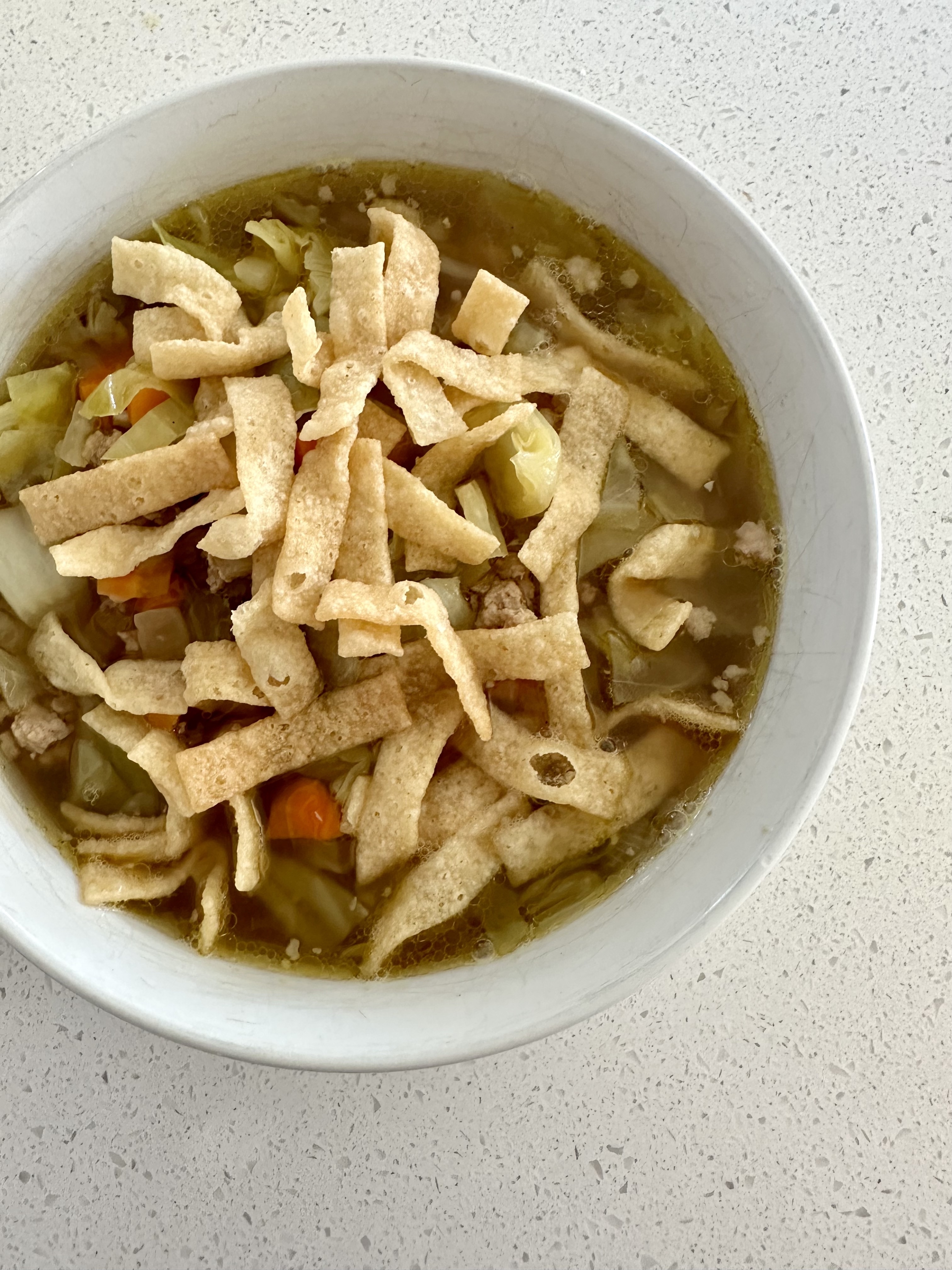 egg roll soup in a bowl with wonton crisps