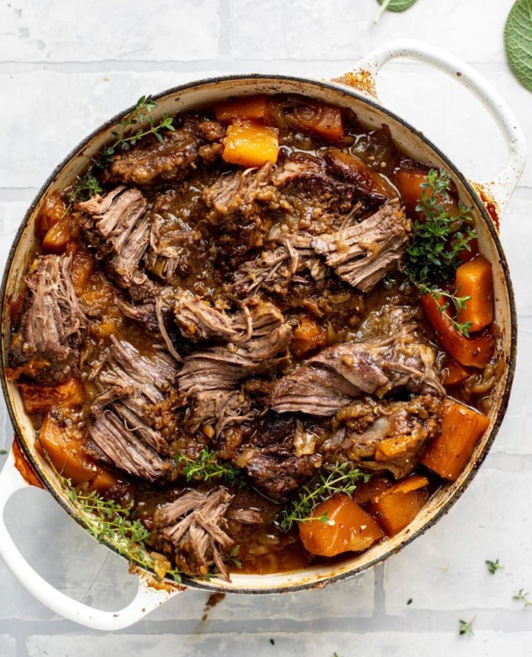 cider braised pot roast with butternut squash in a dutch oven