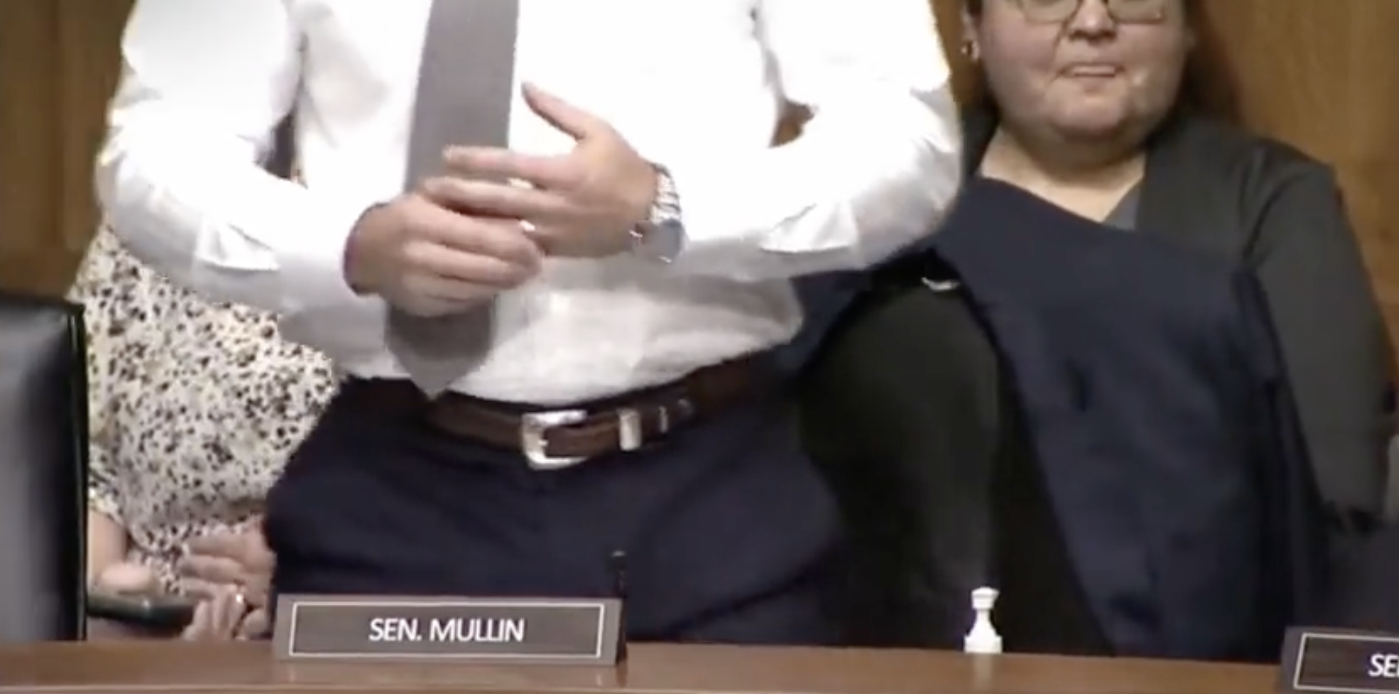 Sen. Mullin standing up and adjusting his ring