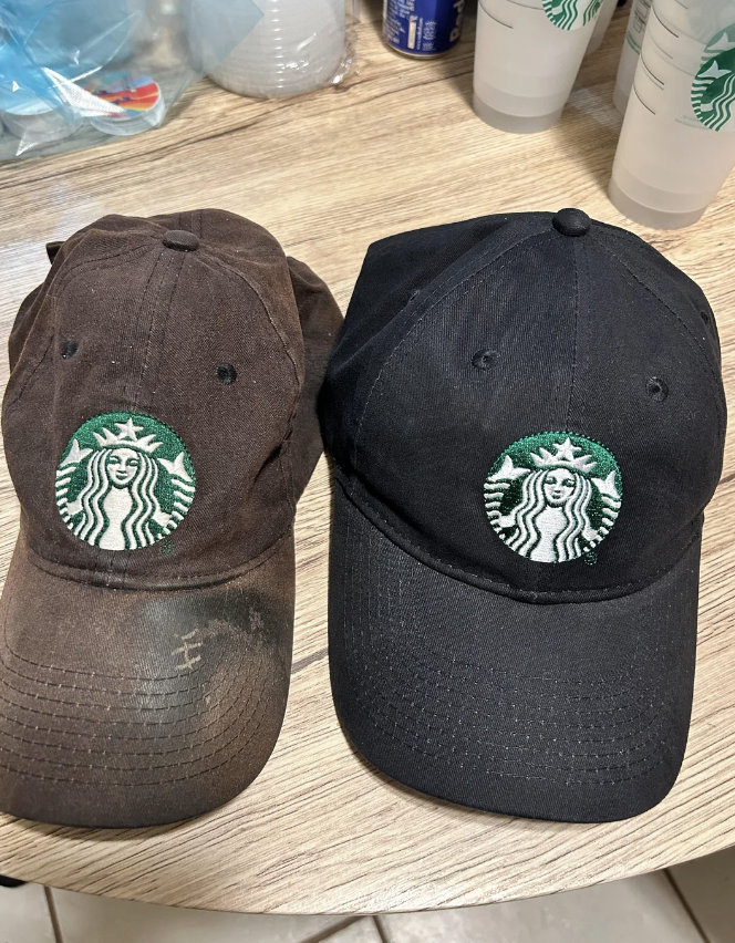 An old barista cap is a dirty dark brown, next to the black new one