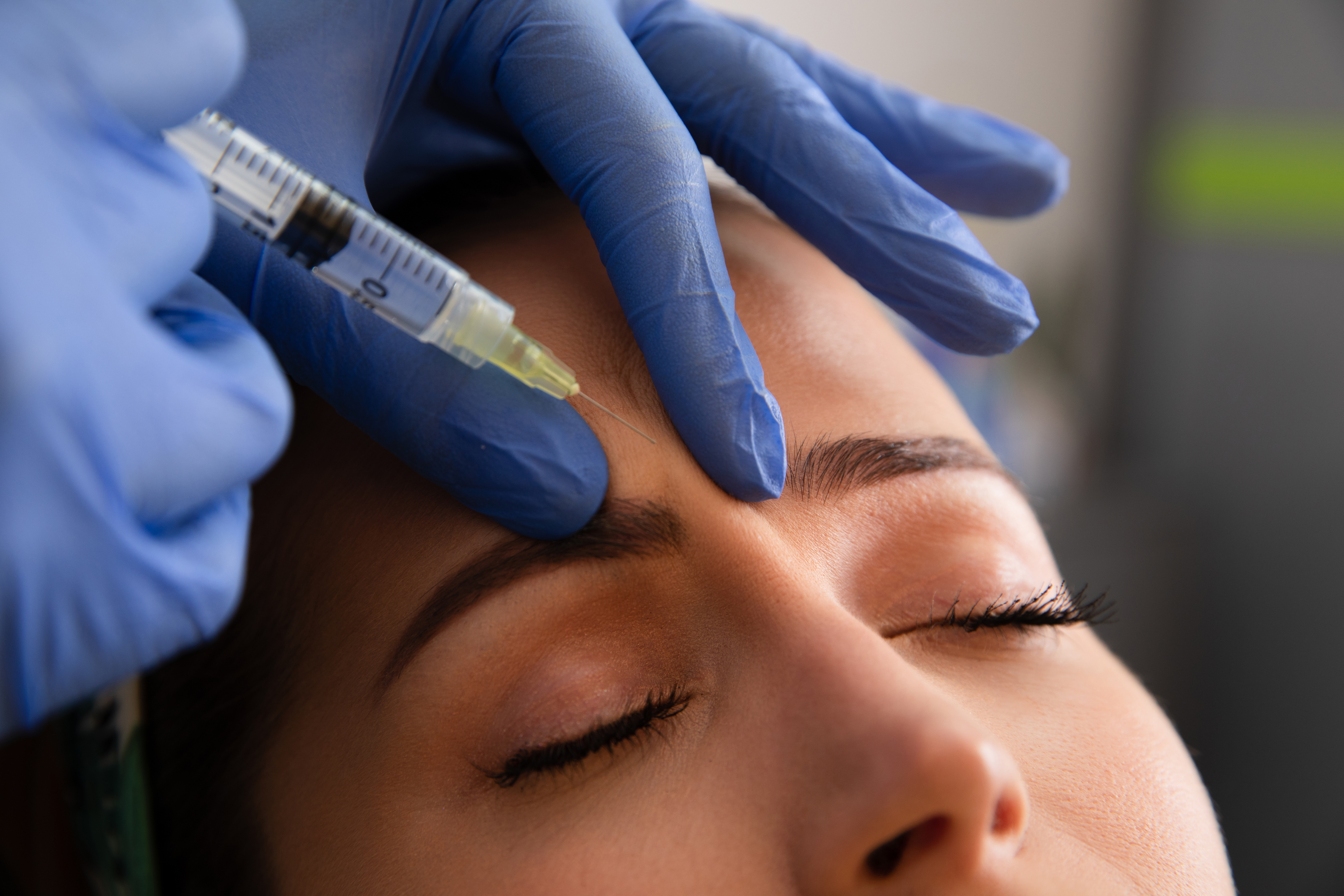 woman getting an injection between her eyebrows