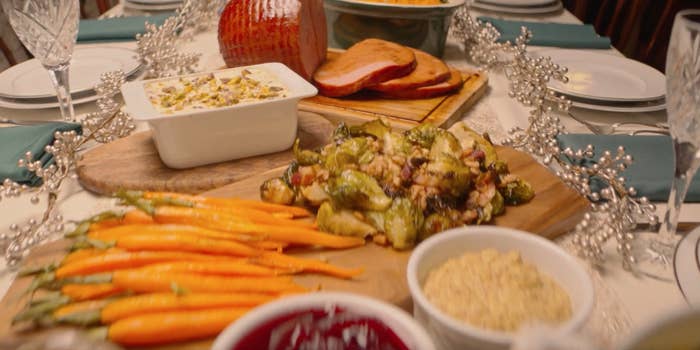 carrots, brussel sprouts, ham and mac and cheese on holiday table spread