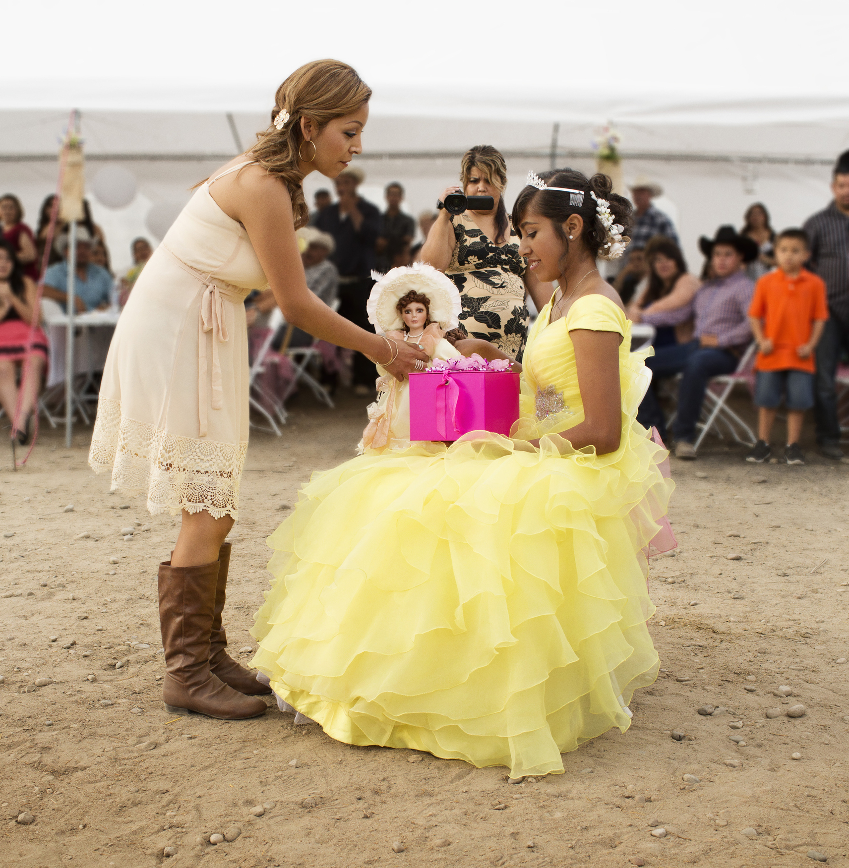 A mother handing her 15-year-old daughter presents on her quinceañera