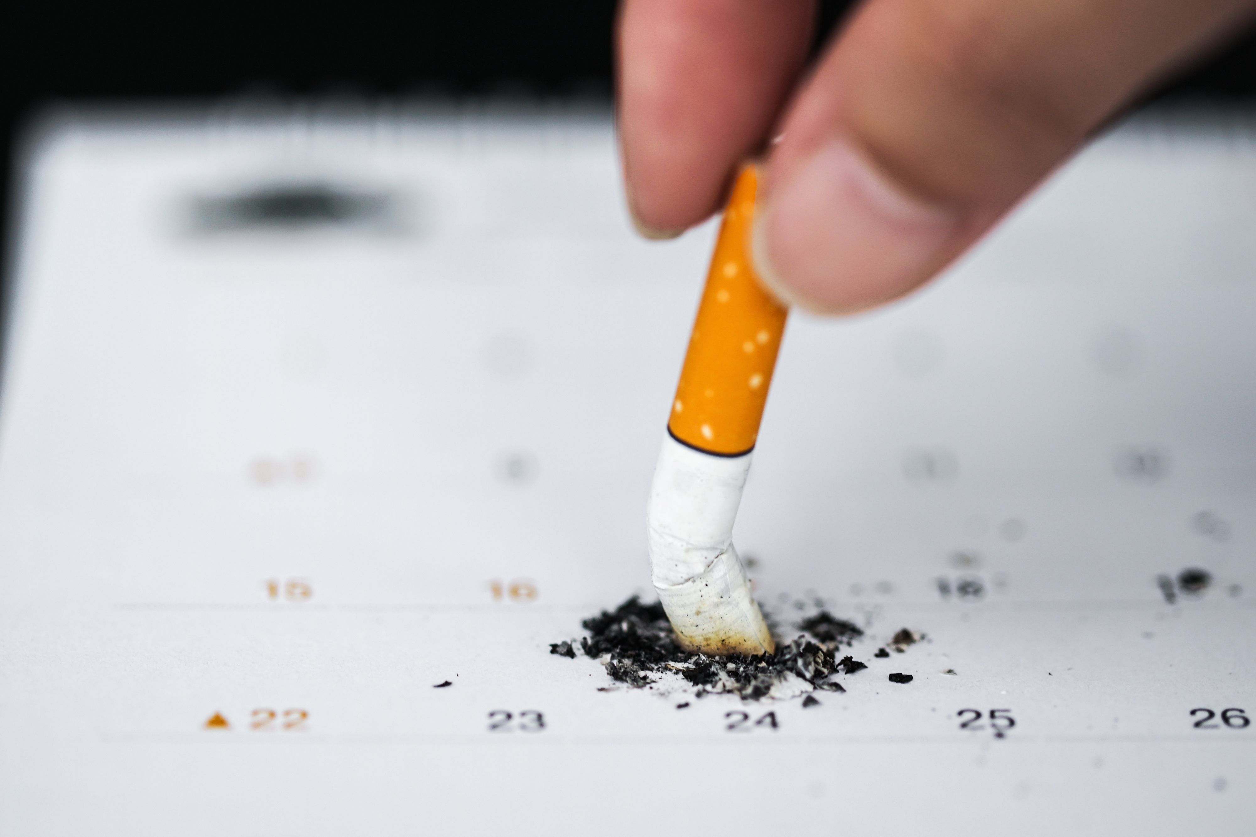 person putting out a cigarette on a calendar