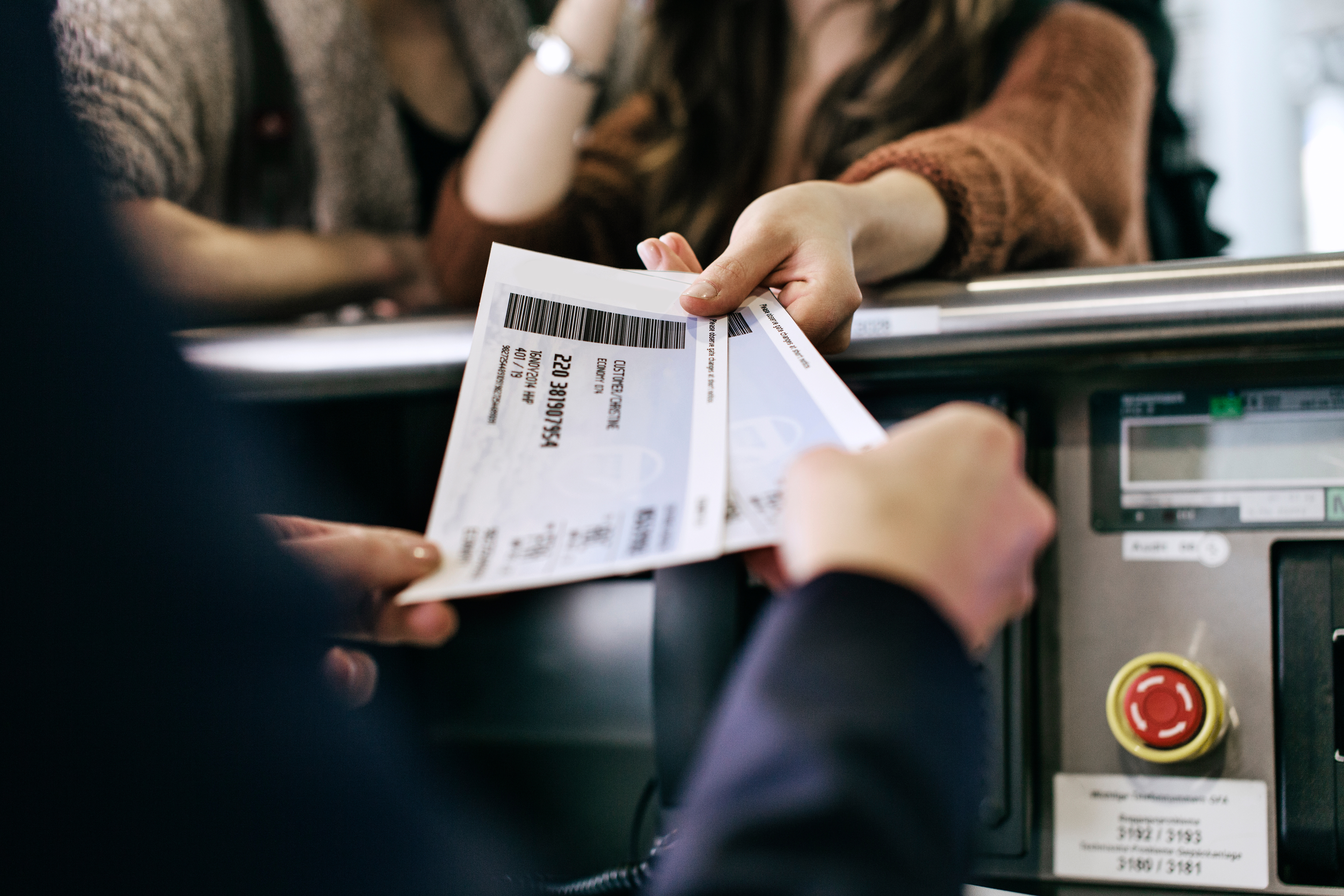 Woman handing her boarding pass for a flight to an airport employee