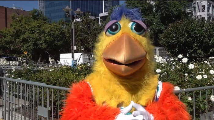 A person is dressed up as a chicken mascot