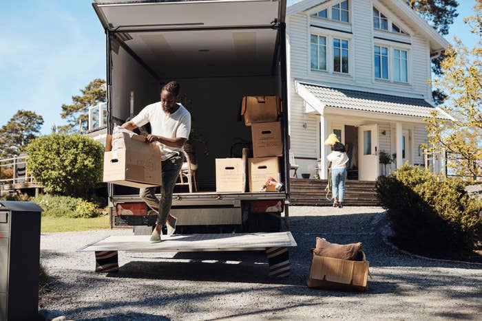People moving boxes from a truck to a new house