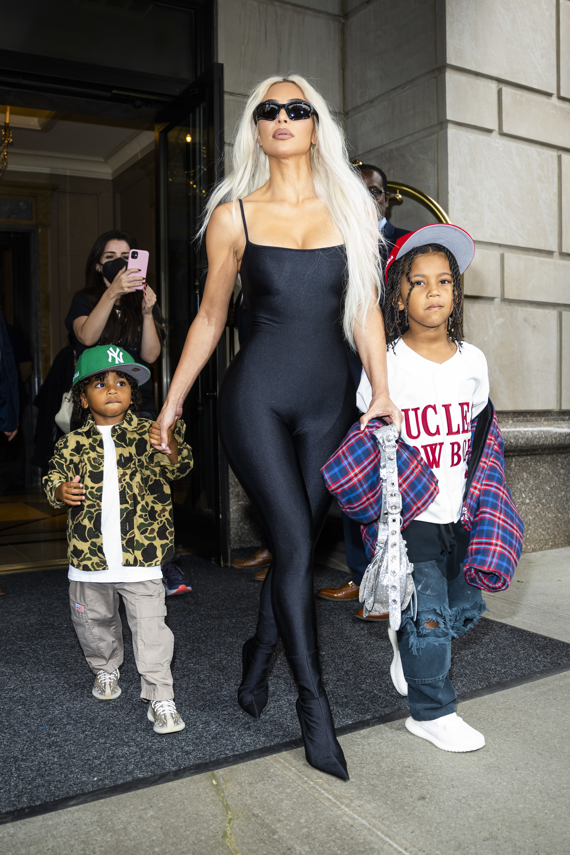 Kim exiting a building with her kids